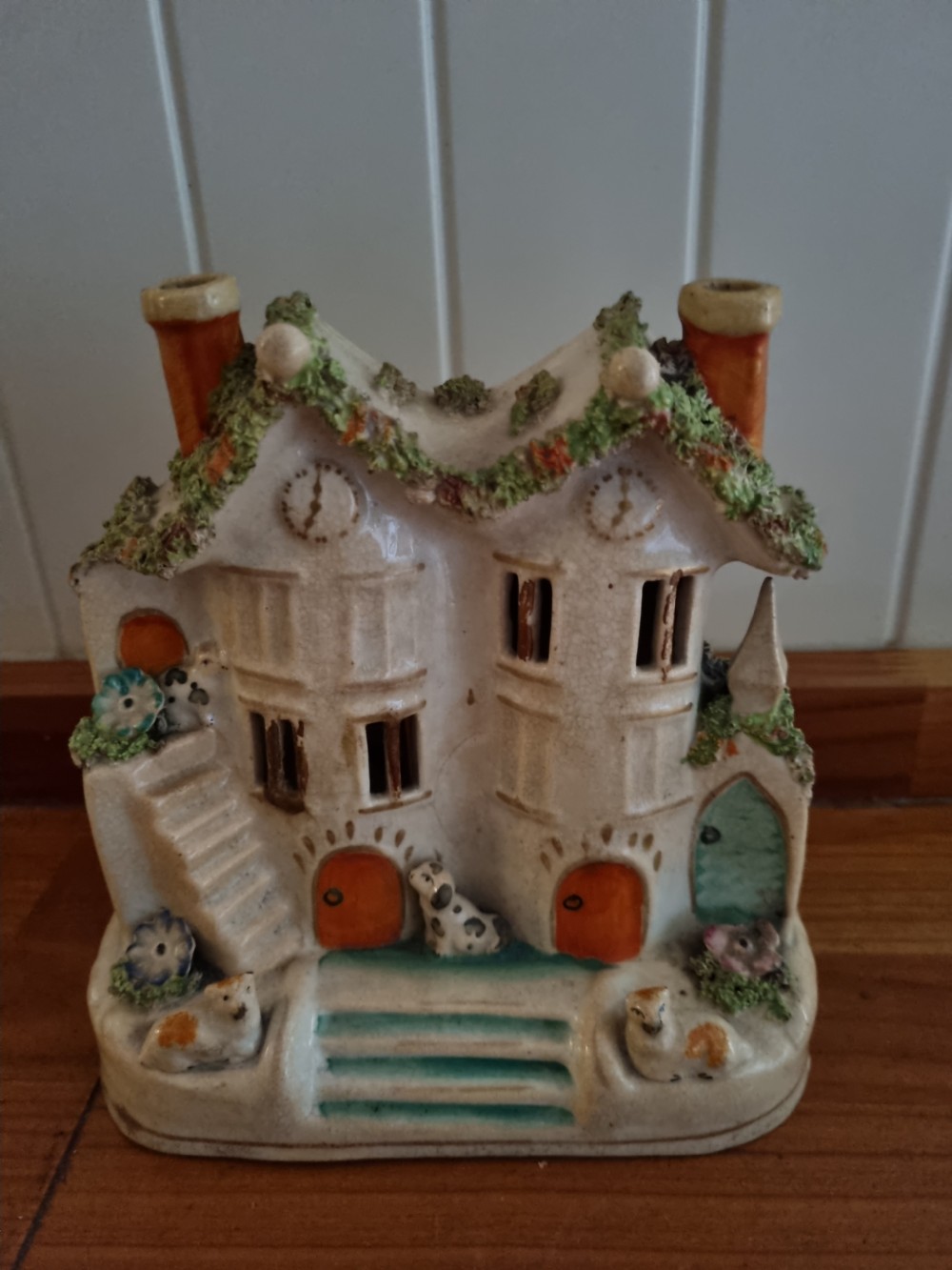 A 19th-century Staffordshire earthenware pastille burner styled as a cream twin-gabled mansion with applied green foliage and painted red doors. View IV