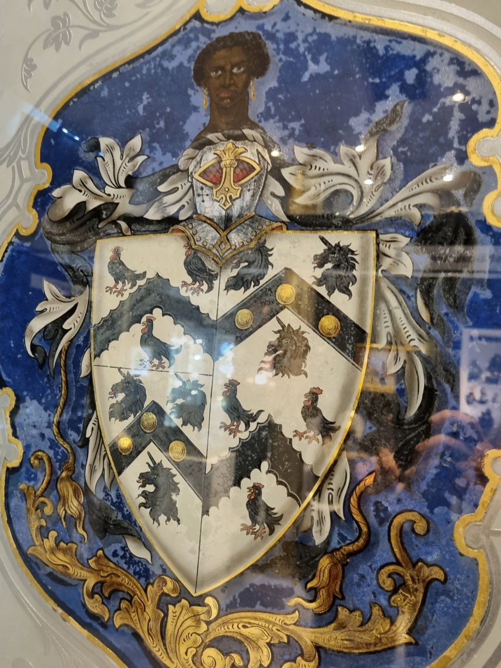 A VERRE EGOMISE GLASS  FRAMED PANEL.BEARING THE ARMS OF ST THOMAS MORE  View II