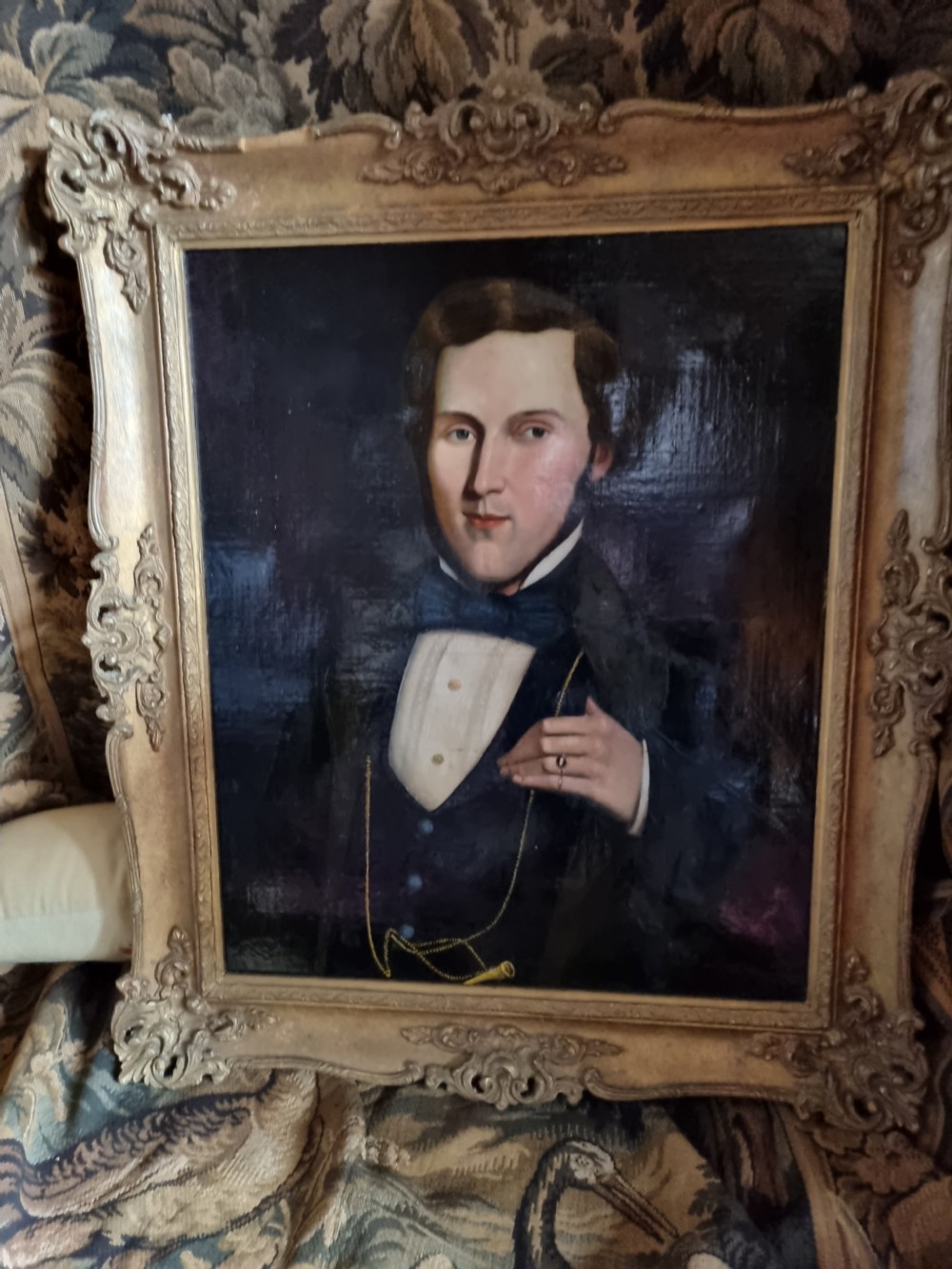A nineteenth-century oil portrait depicting a young gentleman wearing period attire, set within an ornate gilded frame. View V
