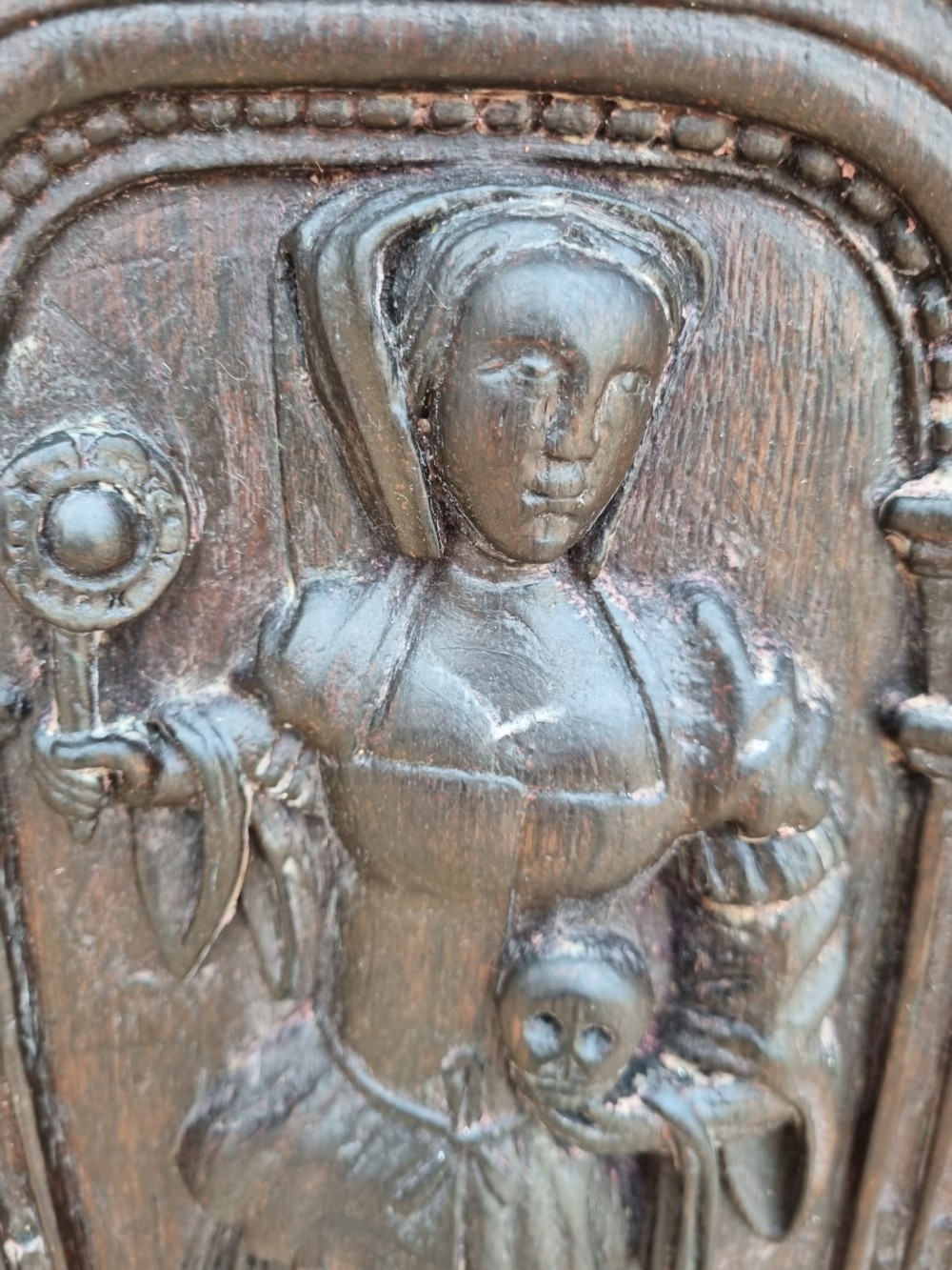 E 17THC OAK CARVED PANEL OF A LADY HOLDING A SKULL AND ORB. View II