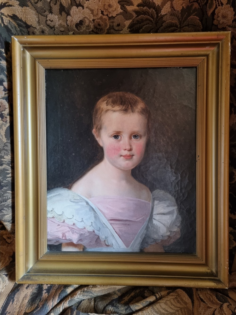 A nineteenth-century framed oil painting depicting a young girl with auburn hair wearing a pink dress with white puffed sleeves. View III