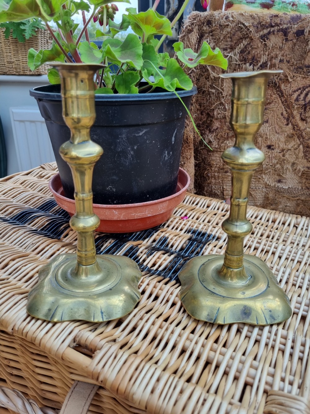 A pair of 18th-century Georgian bell metal candlesticks with turned baluster stems and shaped petal bases. View VI