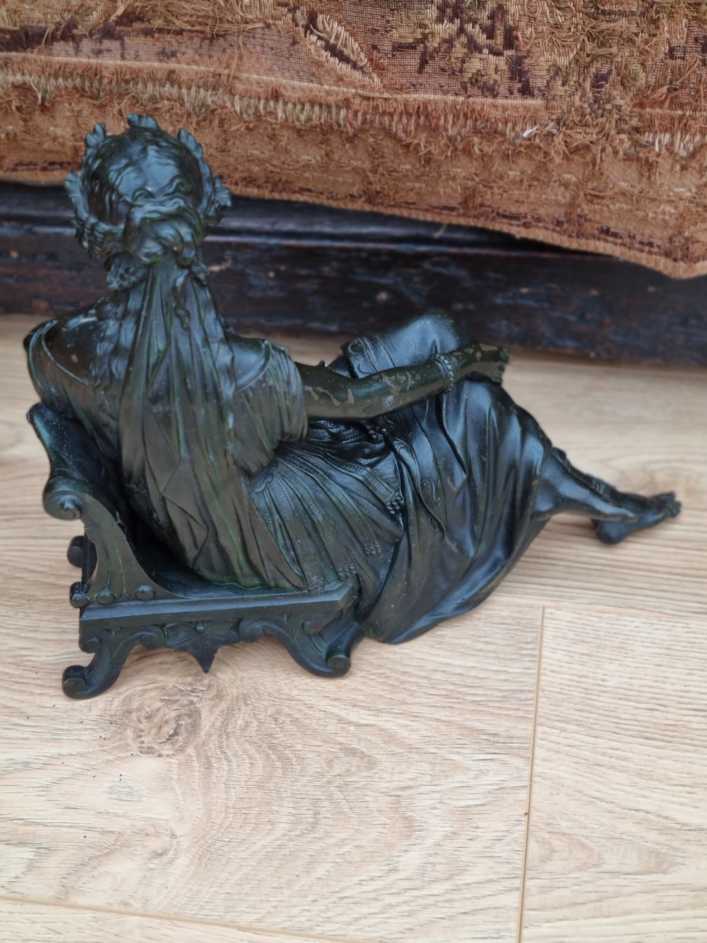 A 19th-century dark green patinated bronze figure depicting a seated classical woman in draped clothing resting her chin on her hand. View III