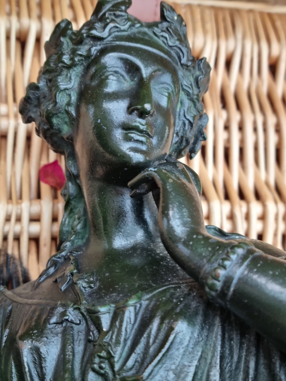 A 19th-century dark green patinated bronze figure depicting a seated classical woman in draped clothing resting her chin on her hand. View V