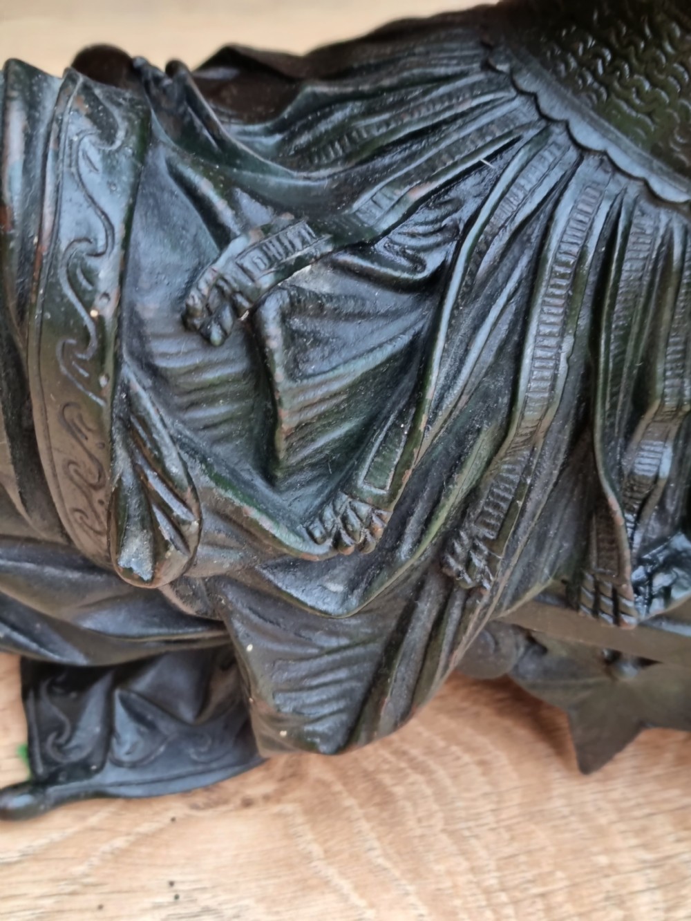 A 19th-century dark green patinated bronze figure depicting a seated classical woman in draped clothing resting her chin on her hand. View VII