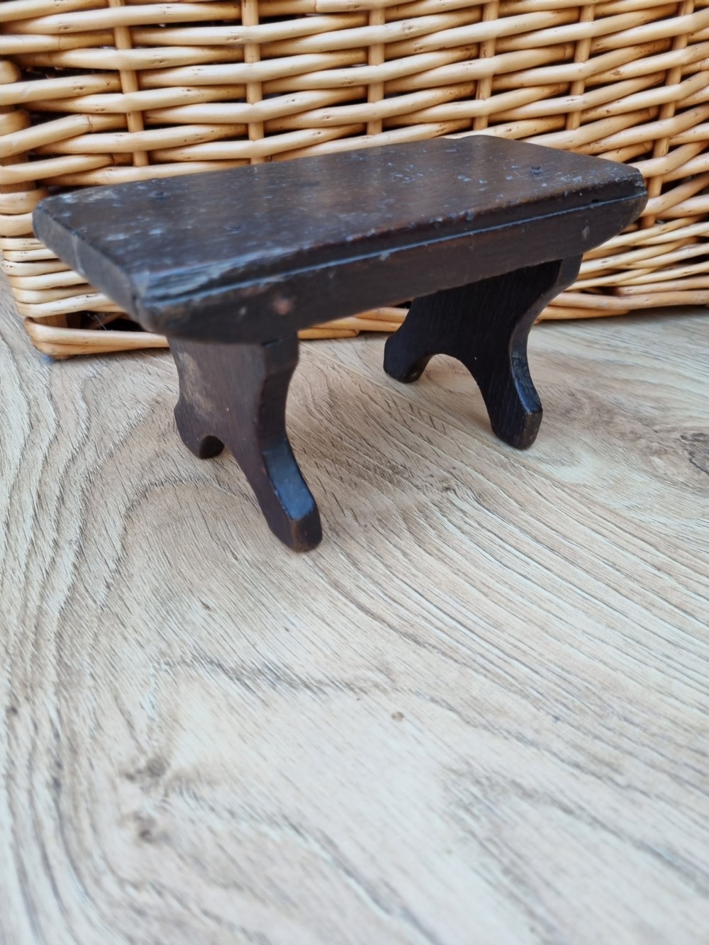 A 19th-century dark elm miniature Welsh stool with a solid rectangular top and carved arch side supports showing age-related wear.