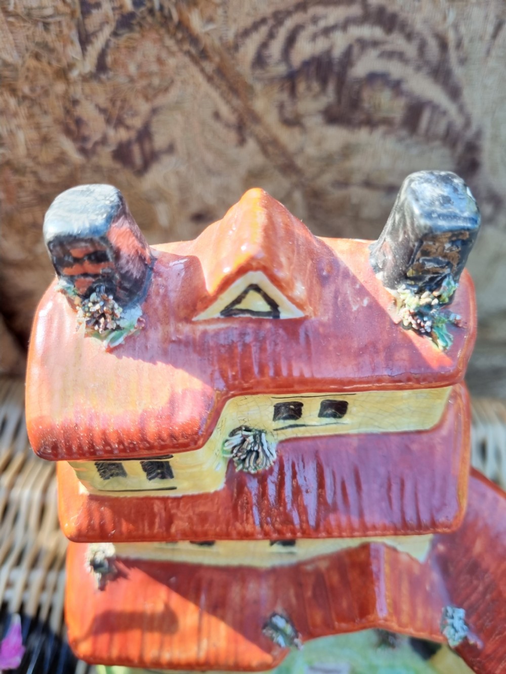 A 19th-century Staffordshire glazed earthenware money box crafted in the form of a multi-storey house with a yellow facade, red tiled roofs, and green base. View V