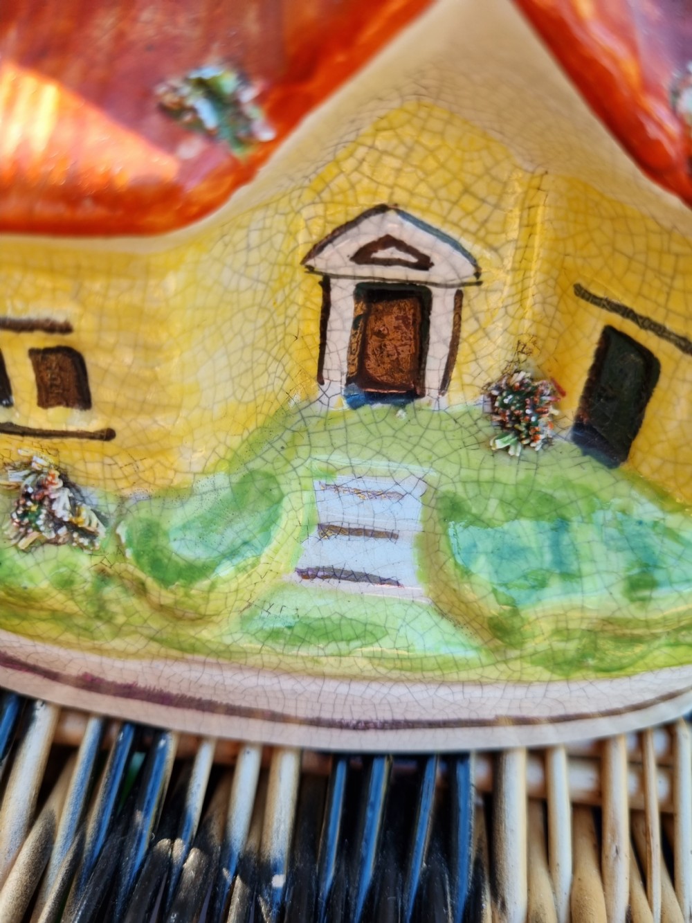A 19th-century Staffordshire glazed earthenware money box crafted in the form of a multi-storey house with a yellow facade, red tiled roofs, and green base. View VI