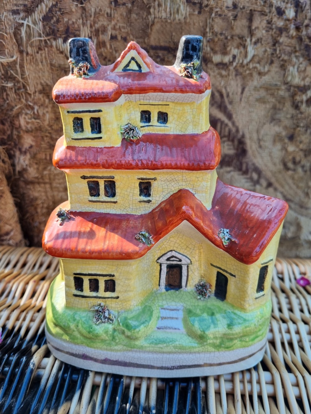 A 19th-century Staffordshire glazed earthenware money box crafted in the form of a multi-storey house with a yellow facade, red tiled roofs, and green base. View VII