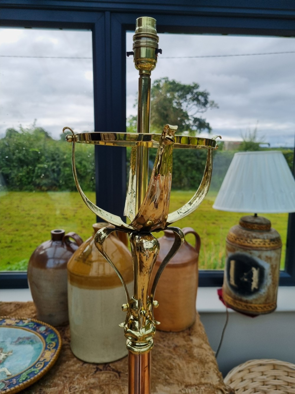 An Arts and Crafts style standard lamp crafted from copper and brass featuring a pyramidal base with decorative relief motifs and an extended central column. View III