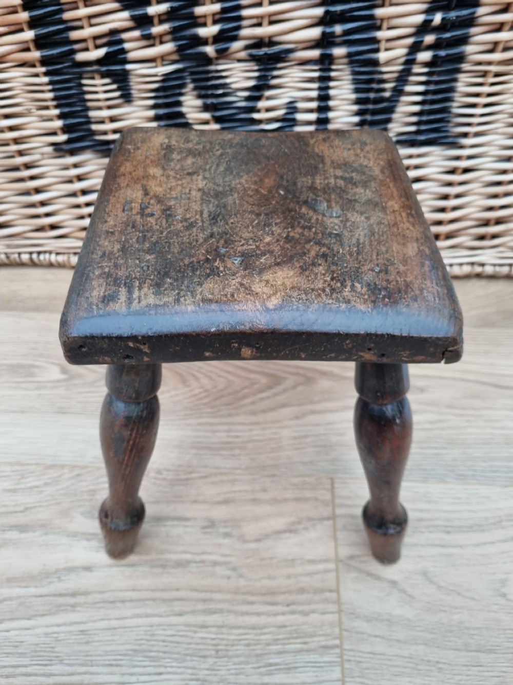 A COUNTRY 19THC TURNED LEG SMALL MILKING STOOL
