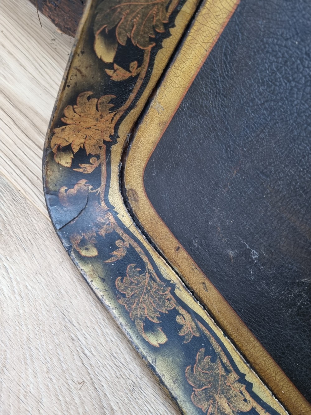 An 18th-century rectangular papier-mache tray featuring a painted landscape scene with figures fishing and a gilded foliate border. View VI