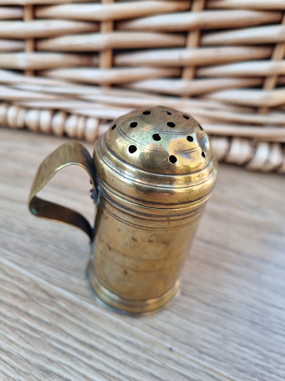 A 19th-century cylindrical brass sugar sifter featuring a perforated domed lid, incised line detailing, and a curved strap handle. View III