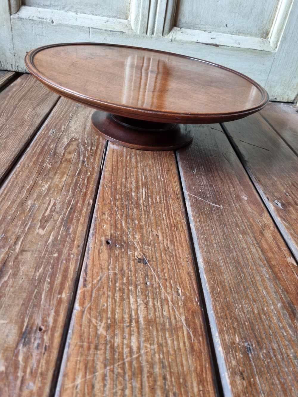 A circular Georgian mahogany Lazy Susan featuring a raised moulded rim and rich wood grain. View III
