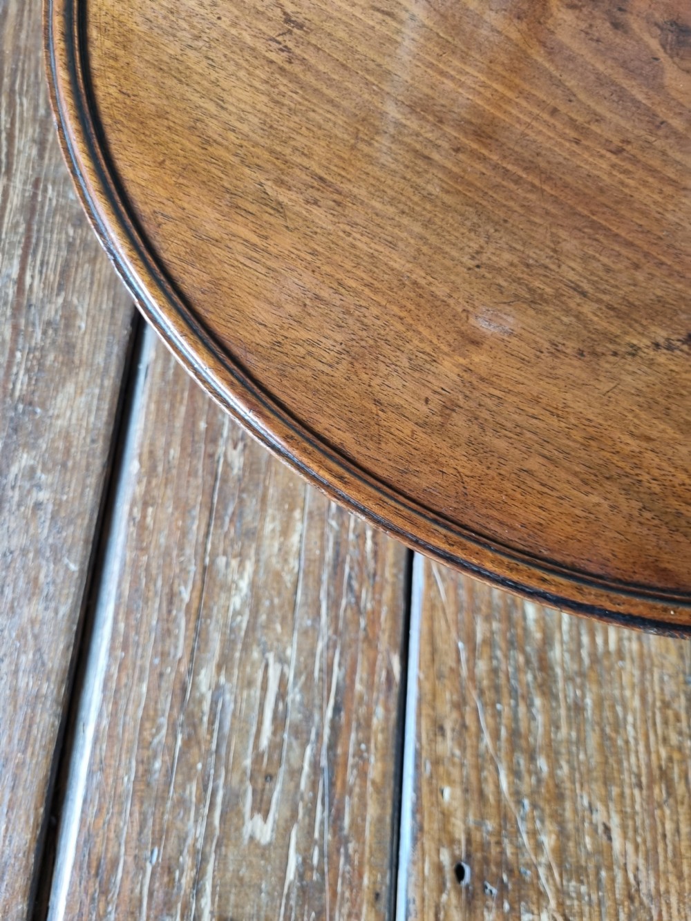 A circular Georgian mahogany Lazy Susan featuring a raised moulded rim and rich wood grain. View IV