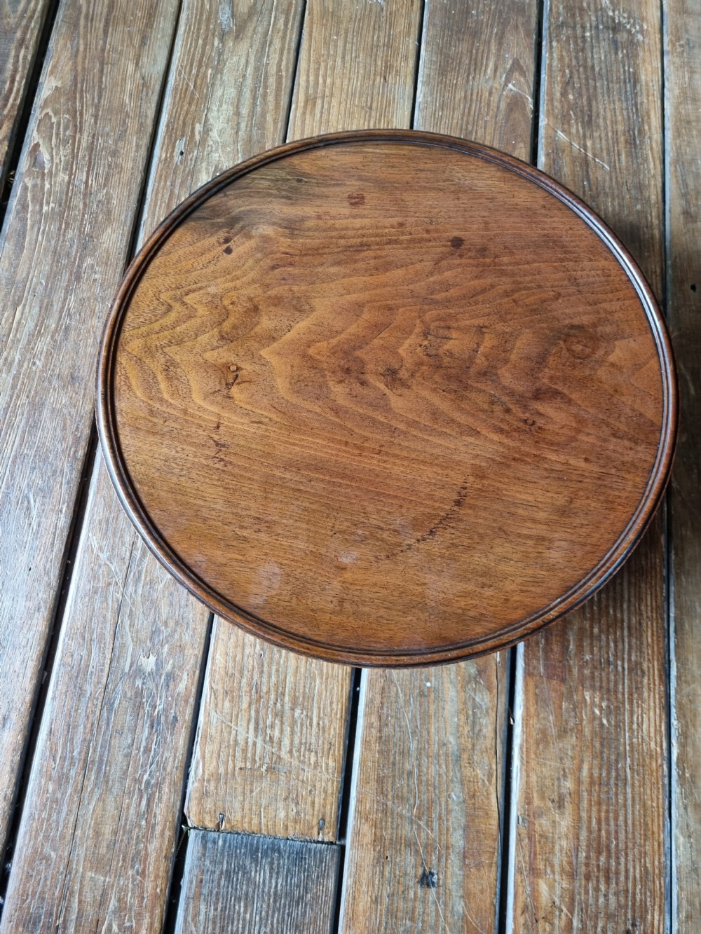 A circular Georgian mahogany Lazy Susan featuring a raised moulded rim and rich wood grain. View V