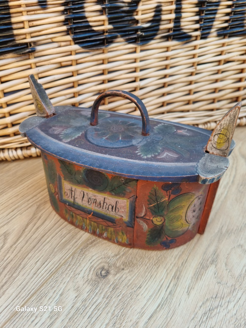 An antique 19th-century Norwegian bentwood tine box with original painted folk art decoration and vertical locking pegs.