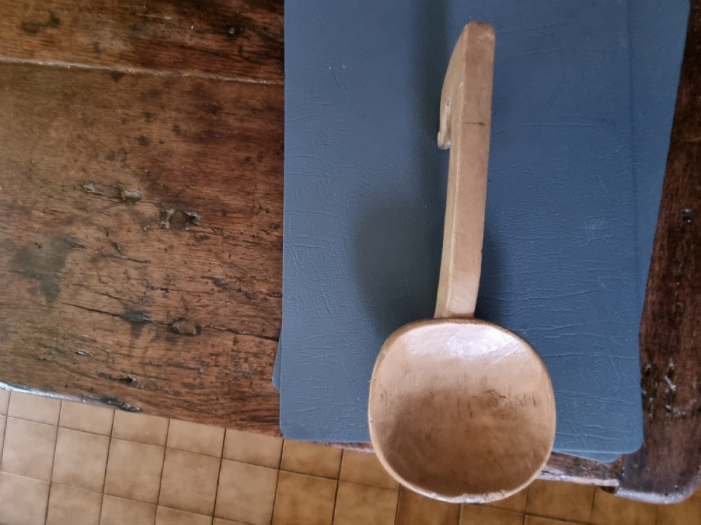 A 19th-century hand-carved Welsh sycamore wooden ladle with a rounded bowl and a hooked handle terminal.
