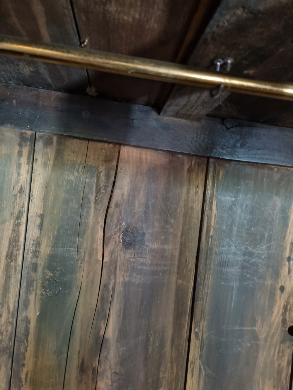An 18th-century dark oak Welsh hanging cupboard featuring three upper drawers above double raised-panel doors. View V