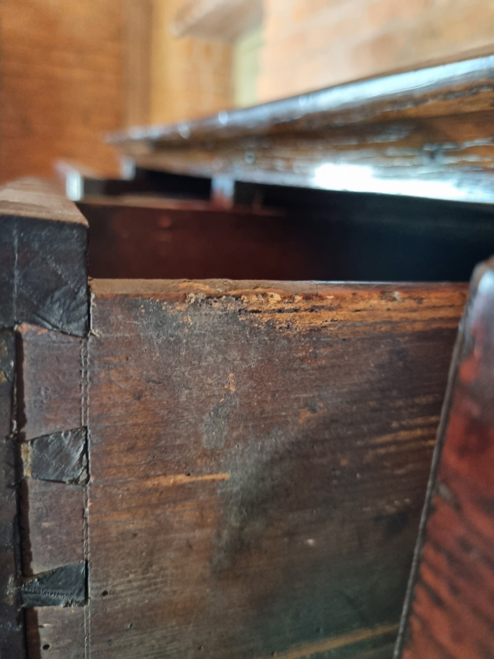 An 18th-century dark oak Welsh hanging cupboard featuring three upper drawers above double raised-panel doors. View VI