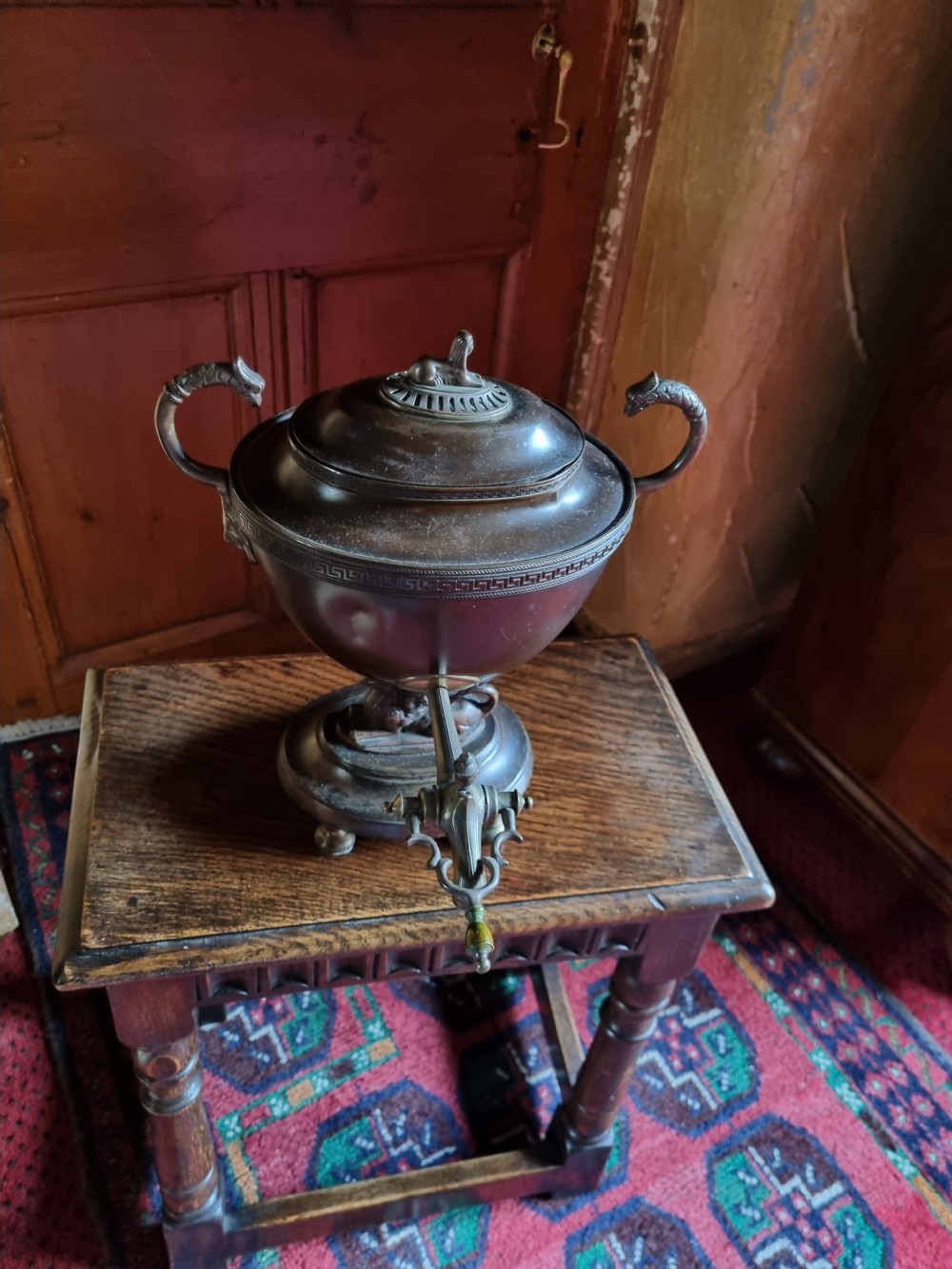 A dark patinated bronze and copper Regency tea samovar featuring a Greek key engraved border, side handles, spigoted tap, and pedestal base. View VI