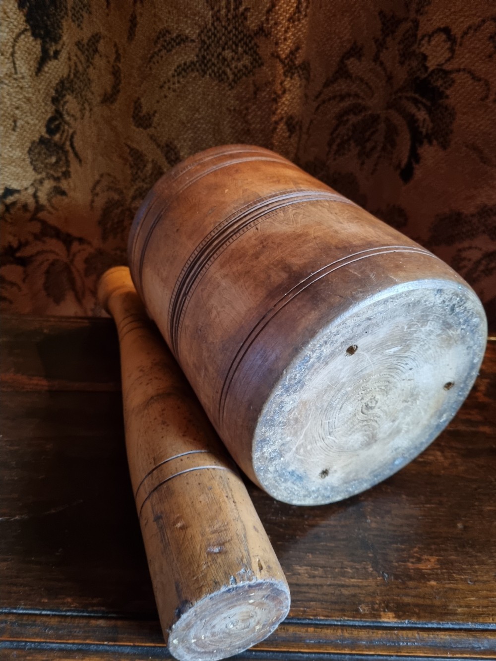An 18th-century turned wooden mortar with a matching pestle showing hand-carved decorative outer rings. View II
