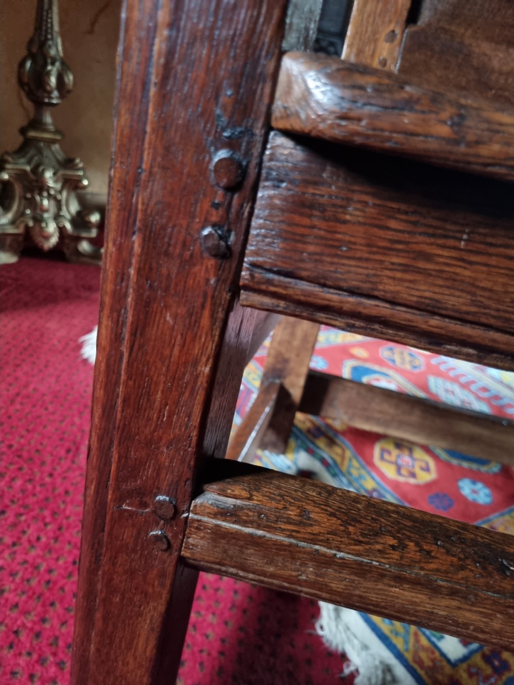 A late 17th-century solid dark oak masters armchair with a panelled backrest, flat armrests, and a wooden plank seat. View IV