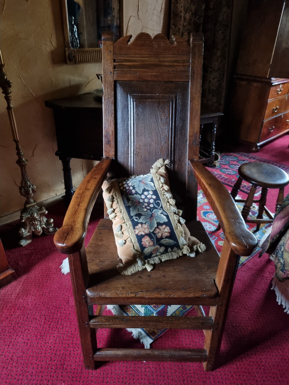 A late 17th-century solid dark oak masters armchair with a panelled backrest, flat armrests, and a wooden plank seat. View V