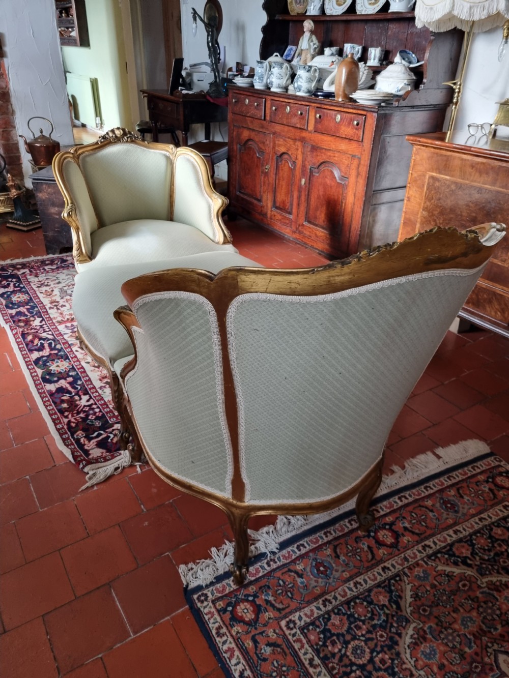 A 19th-century three-piece French duchesse brisee seating set featuring carved giltwood frames and sage green upholstery. View V
