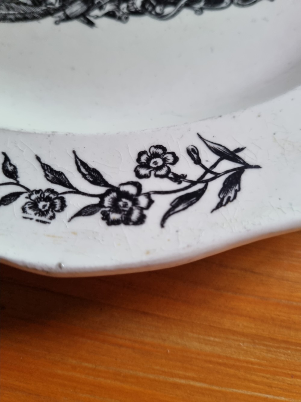 A late eighteenth or early nineteenth-century scalloped creamware plate featuring a central black transfer-printed sailing ship surrounded by floral border sprays. View III