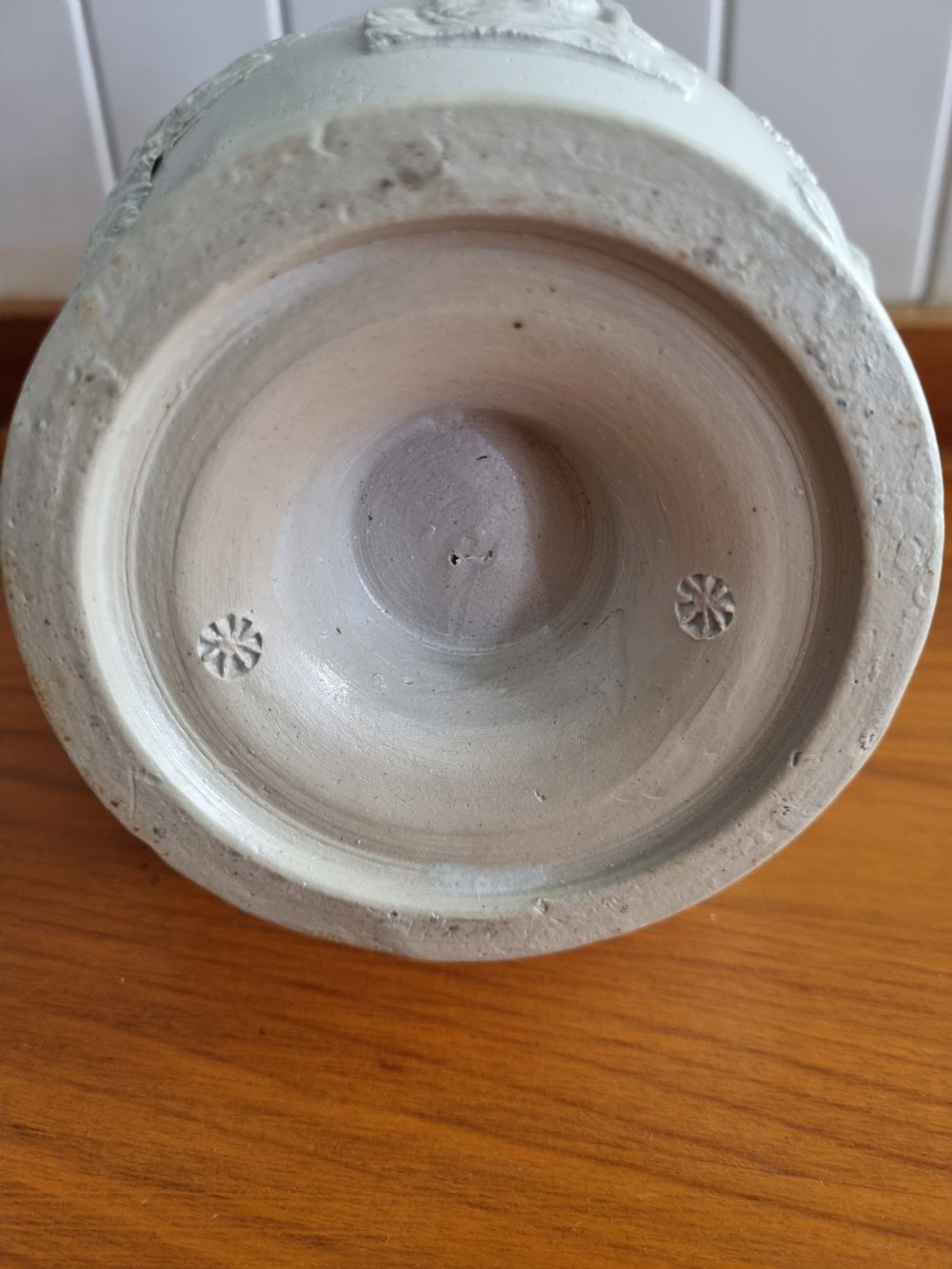 A 19th-century salt-glazed stoneware puzzle jug featuring a brown pierced upper neck, a cream body with a windmill relief decoration, and a hollow loop handle. View II