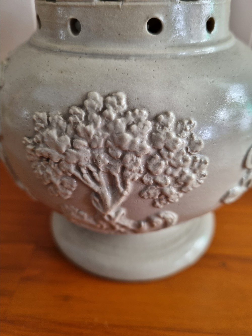 A 19th-century salt-glazed stoneware puzzle jug featuring a brown pierced upper neck, a cream body with a windmill relief decoration, and a hollow loop handle. View III
