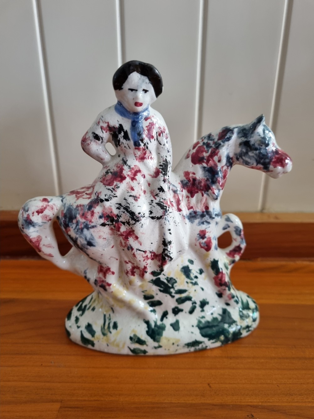 A 19th-century Scottish Portobello earthenware figure depicting a lady seated side-saddle on a horse with hand-sponged polychrome decoration on a cream glaze. View VI