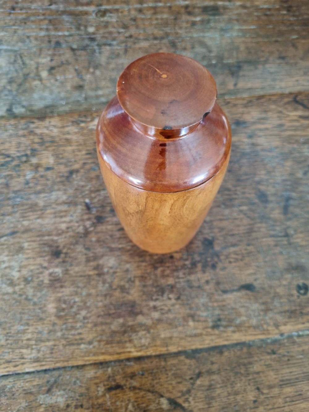 A pair of 19th-century turned sycamore wood jars with fitted covers, displaying a warm honey-brown finish and subtle grain patterns. View V
