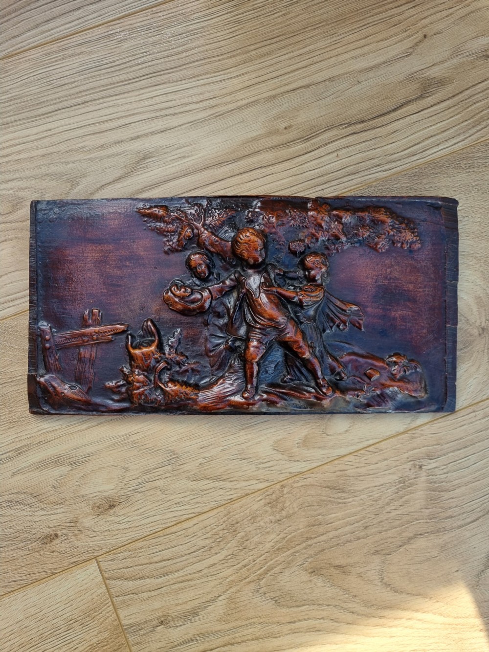 A 18THC WALNUT CARVED PANEL OF CHILDREN PLAYING