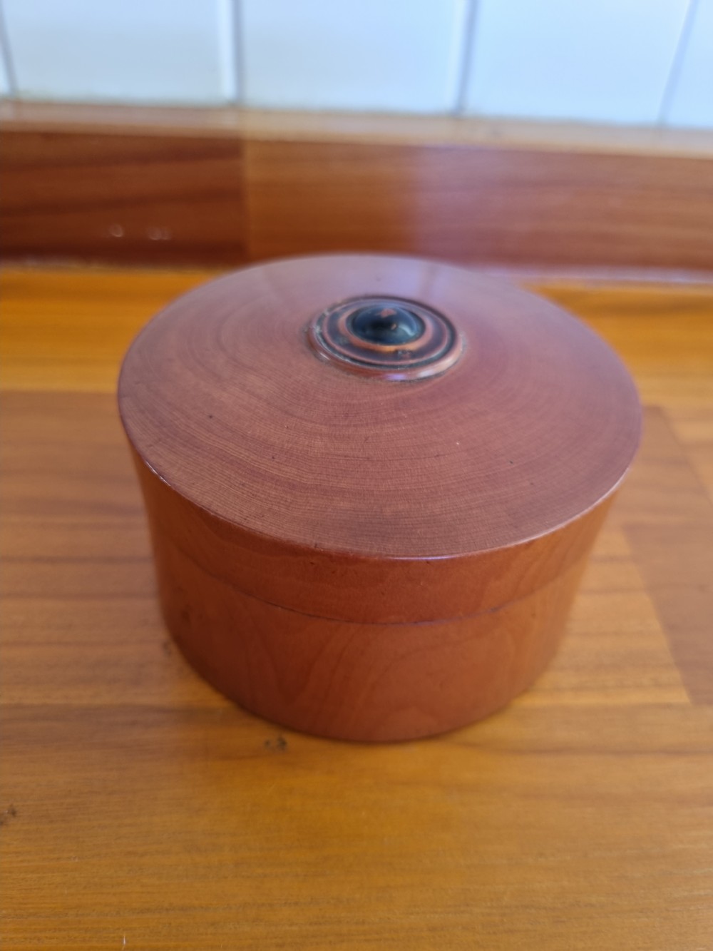 A set of 19th-century turned boxwood nesting containers with fitted lids displayed open on a wooden surface. View II