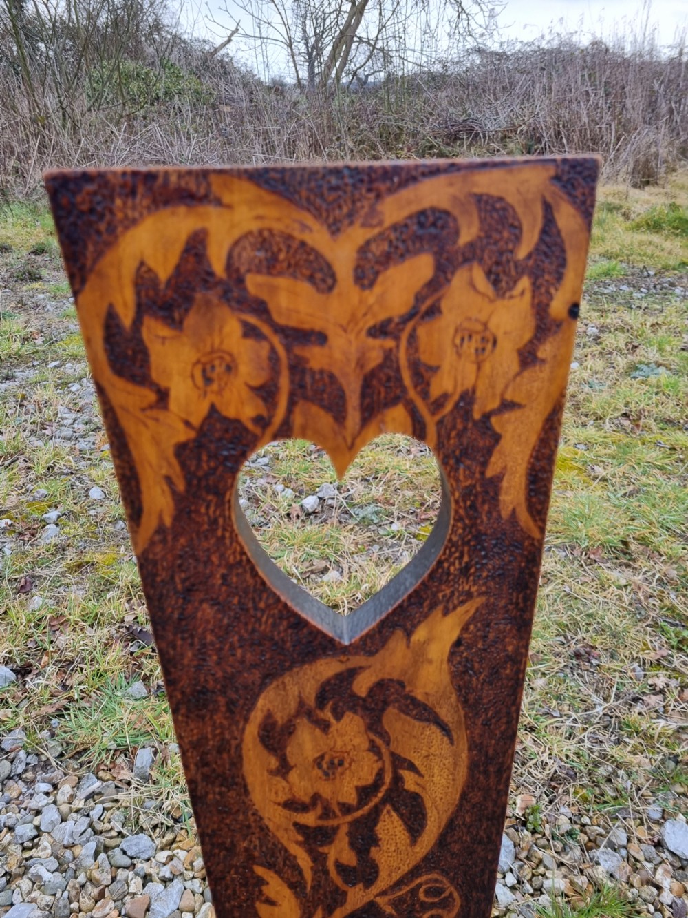 A 19th-century Welsh folk art spinning chair with a tall back featuring a heart cut-out, floral pyrography, a hexagonal seat with a carved dragon motif, and four turned legs. View II