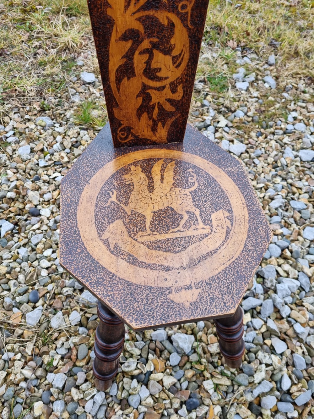 A 19th-century Welsh folk art spinning chair with a tall back featuring a heart cut-out, floral pyrography, a hexagonal seat with a carved dragon motif, and four turned legs. View III