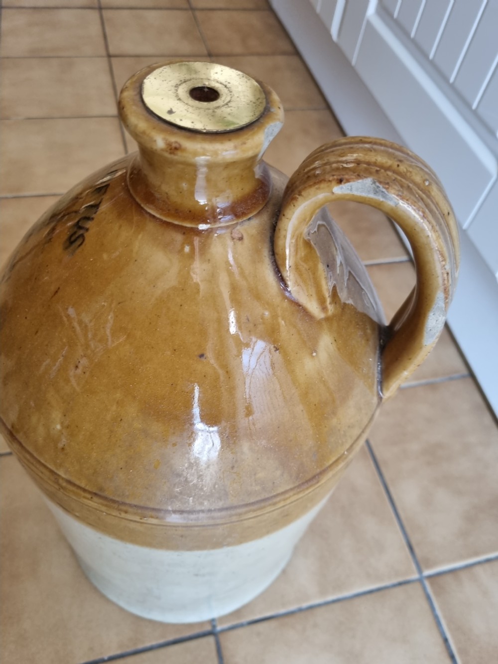 A nineteenth-century two-tone stoneware spirit jug featuring a brown glazed upper section with stamped text reading W.R. Loftus London above an off-white lower section. View III