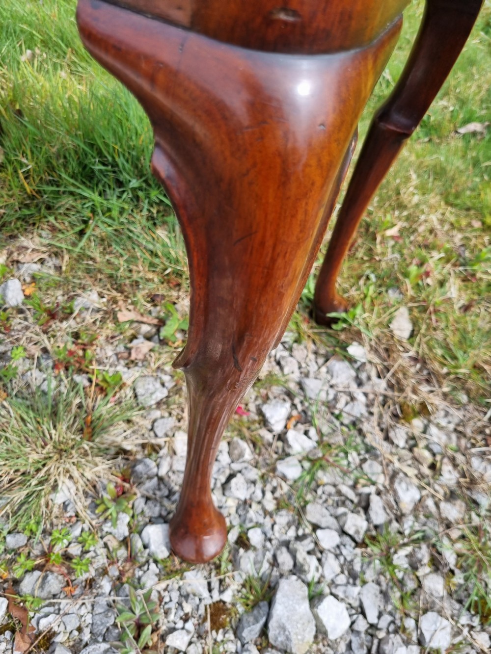 An Early Georgian walnut lowboy table featuring a single drawer with brass handles, crossbanded top border, and cabriole legs with pad feet. View VI