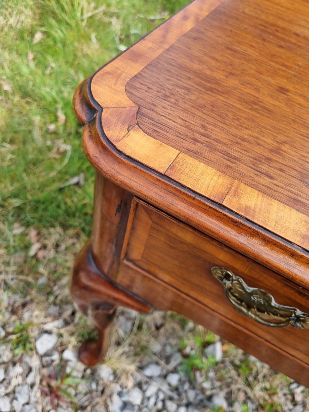 An Early Georgian walnut lowboy table featuring a single drawer with brass handles, crossbanded top border, and cabriole legs with pad feet. View VIII