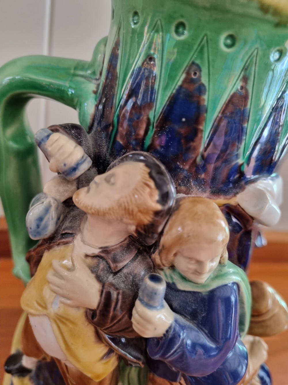 A Victorian Minton majolica ceramic jug decorated with high-relief figures of dancing couples in polychrome glazes against a dark blue background. View VI