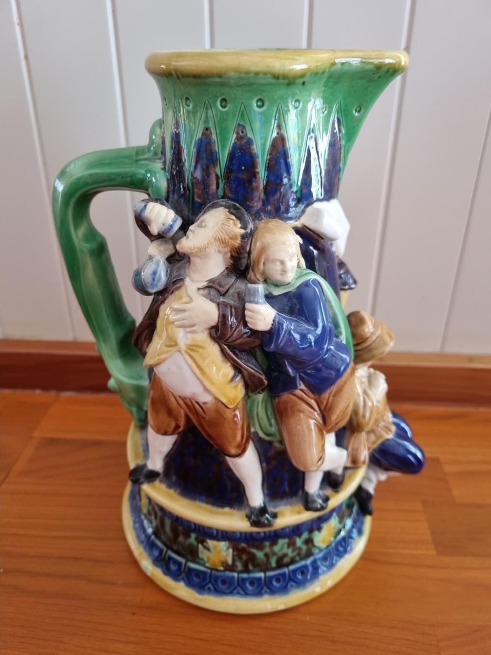 A Victorian Minton majolica ceramic jug decorated with high-relief figures of dancing couples in polychrome glazes against a dark blue background. View VIII