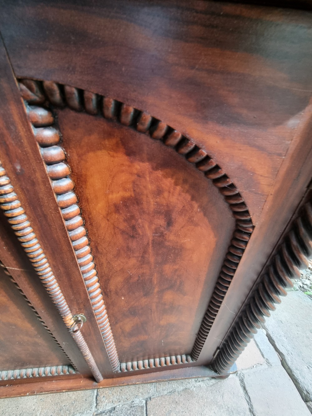 A 19th-century dark brown painted pine cupboard featuring double arched-panel doors, rope-twist corner columns, and beaded decorative trim. View V