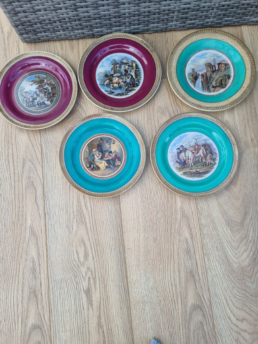 A collection of five 19th-century Prattware earthenware plates featuring central pictorial transfer prints enclosed by maroon and teal borders with gilded detailing.