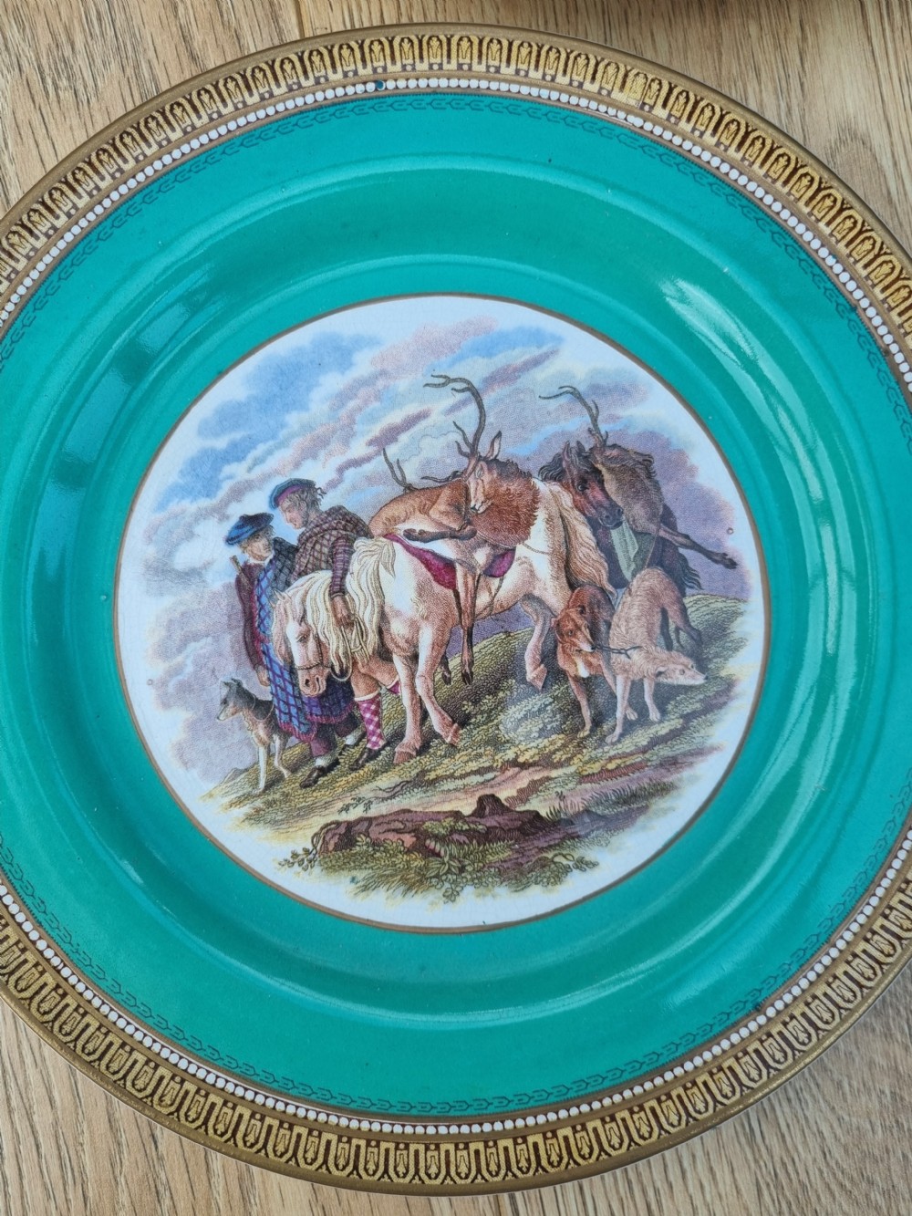 A collection of five 19th-century Prattware earthenware plates featuring central pictorial transfer prints enclosed by maroon and teal borders with gilded detailing. View II