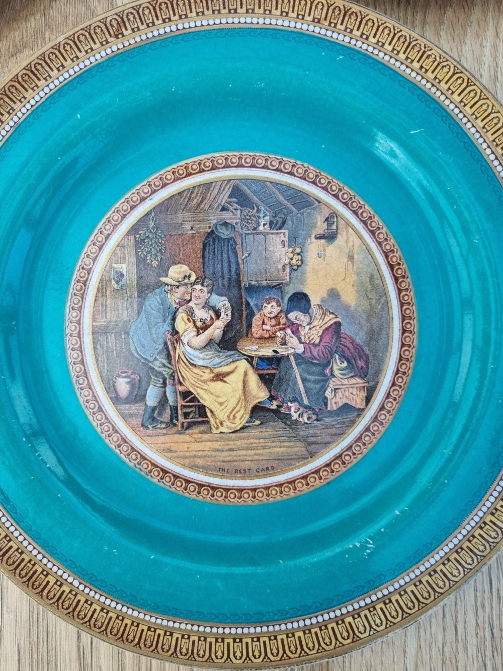 A collection of five 19th-century Prattware earthenware plates featuring central pictorial transfer prints enclosed by maroon and teal borders with gilded detailing. View III