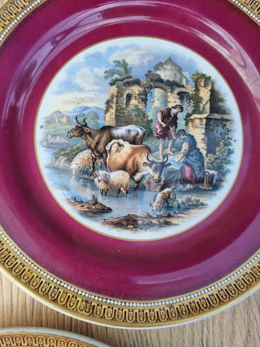 A collection of five 19th-century Prattware earthenware plates featuring central pictorial transfer prints enclosed by maroon and teal borders with gilded detailing. View VI