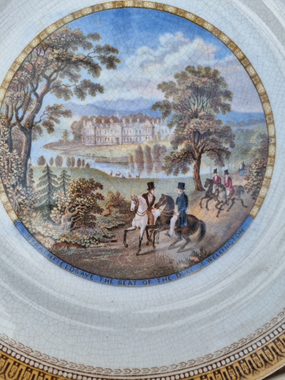 A set of five circular Victorian Prattware ceramic plates featuring polychrome transfer-printed pastoral landscape scenes with decorative gold geometric borders. View V