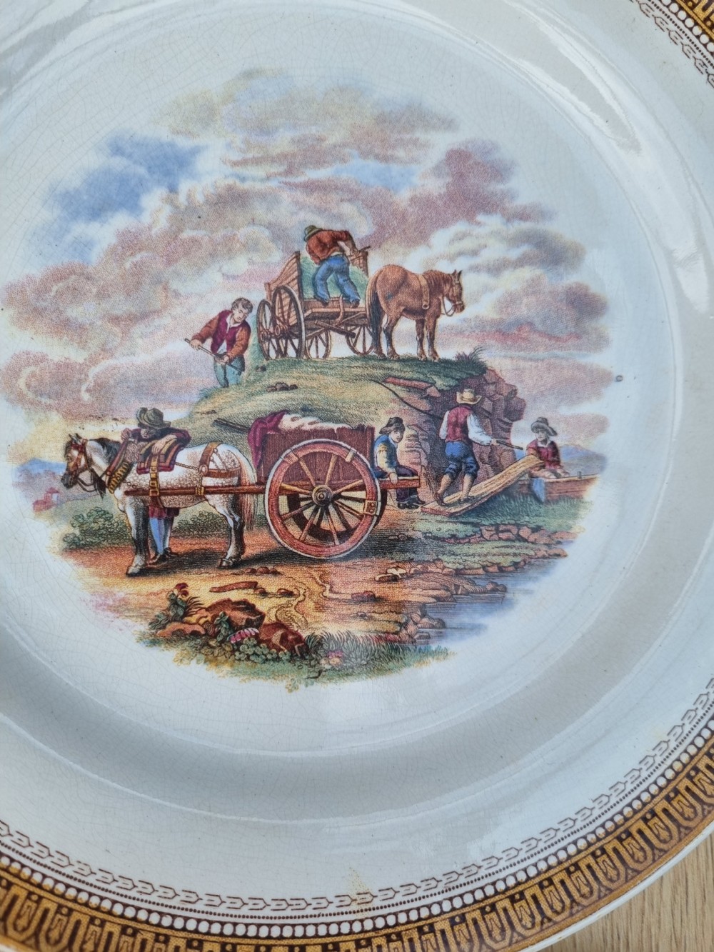 A set of five circular Victorian Prattware ceramic plates featuring polychrome transfer-printed pastoral landscape scenes with decorative gold geometric borders. View VI